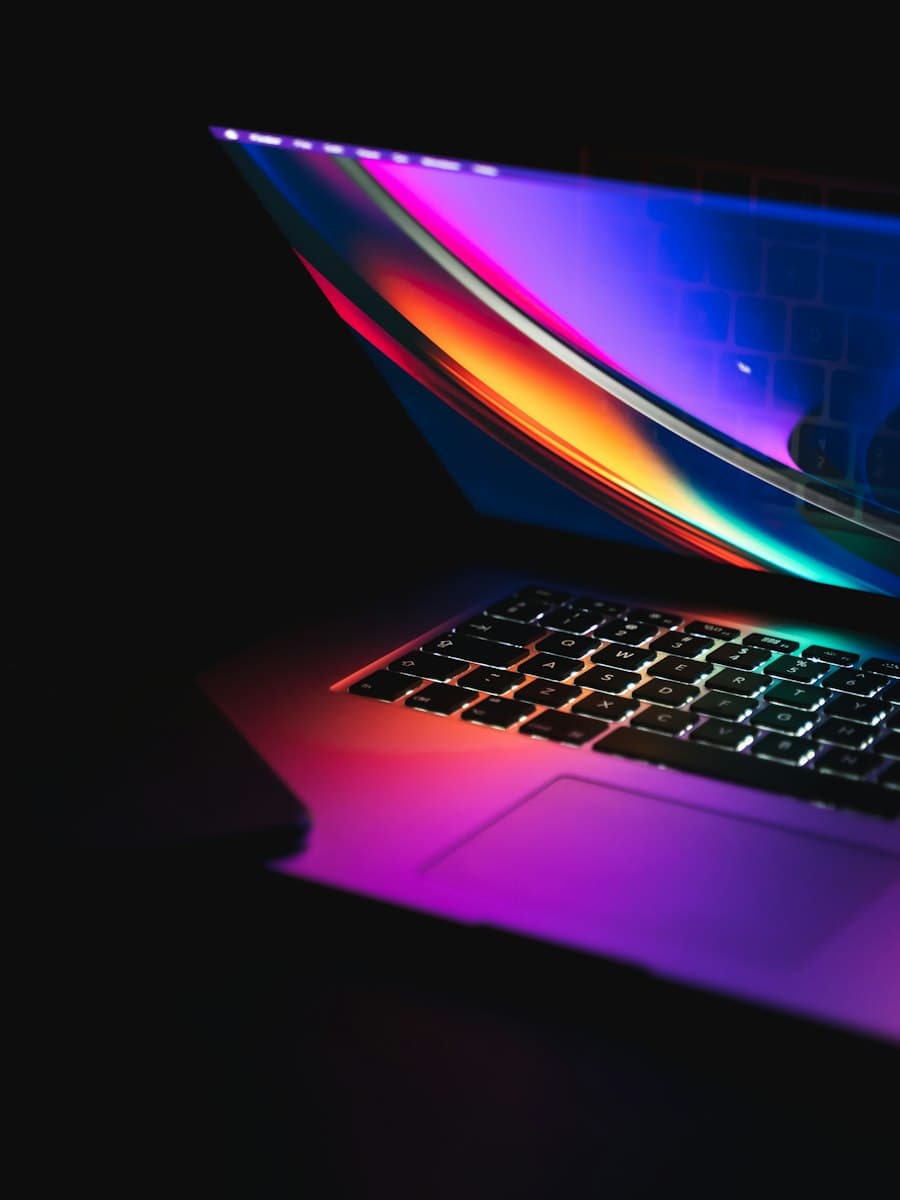 Laptop glowing with colourful light in the dark