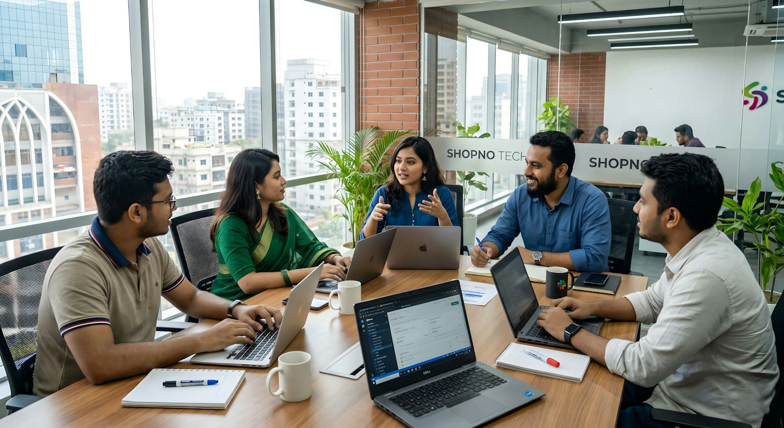 A team meeting around a table with laptops